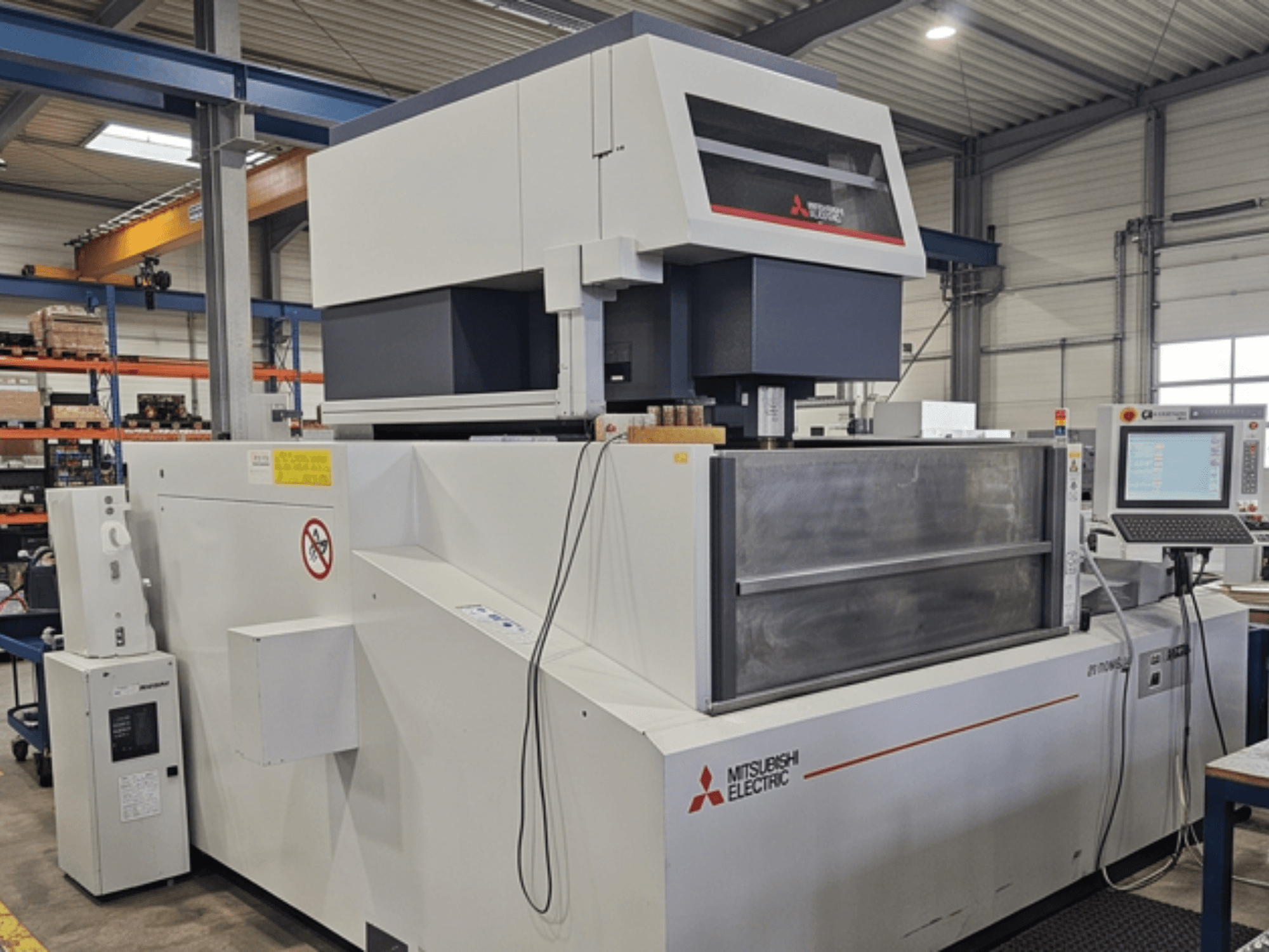 Macchina per elettroerosione a filo Mitsubishi MV-4800, vista frontale, che mostra il pannello di controllo e l'area di lavoro in un ambiente industriale.