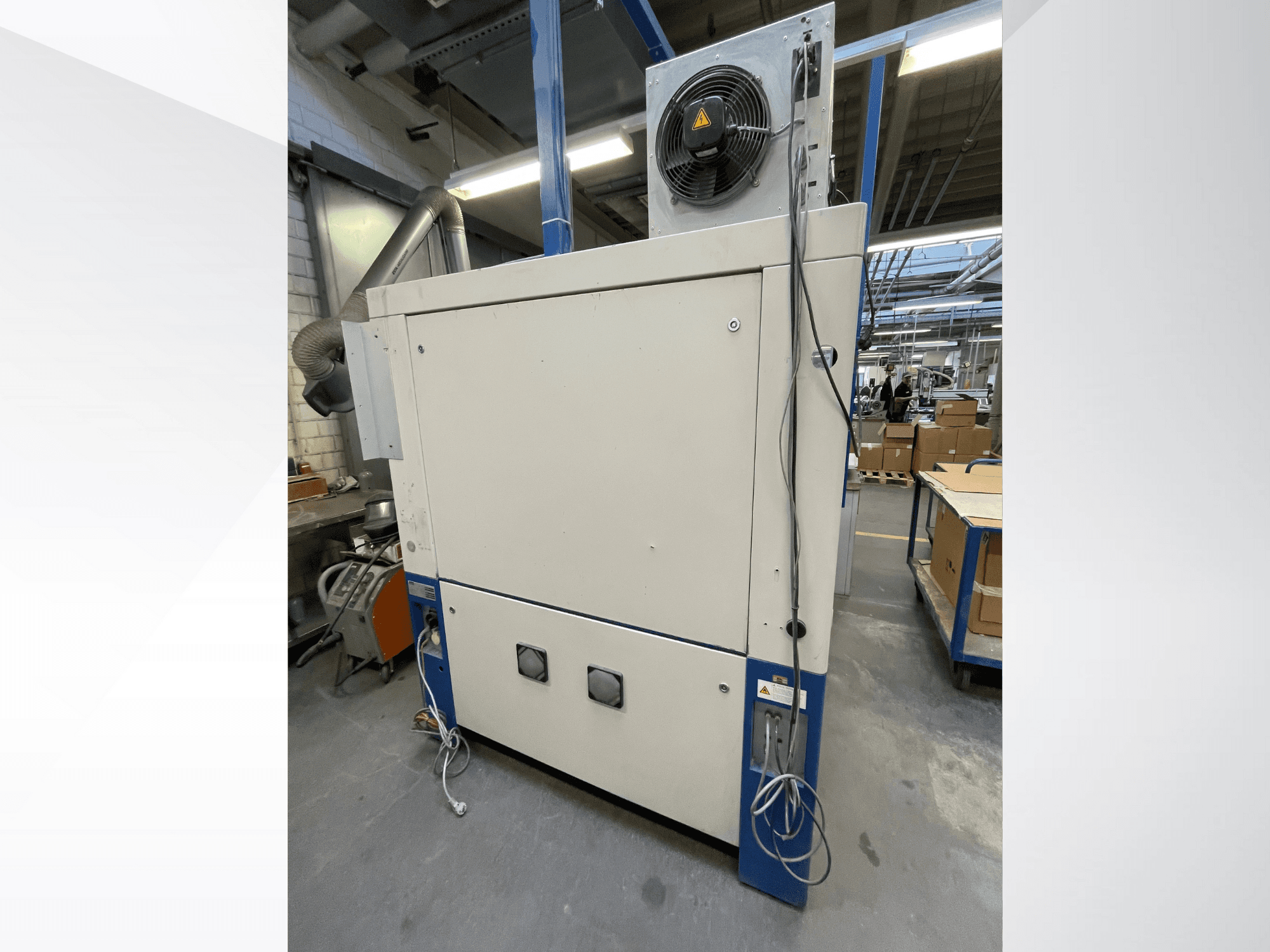 Asciugatrice industriale con ventilatore, vista laterale; dispone di ventilazione e connessioni elettriche multiple. Marca/modello non visibile.