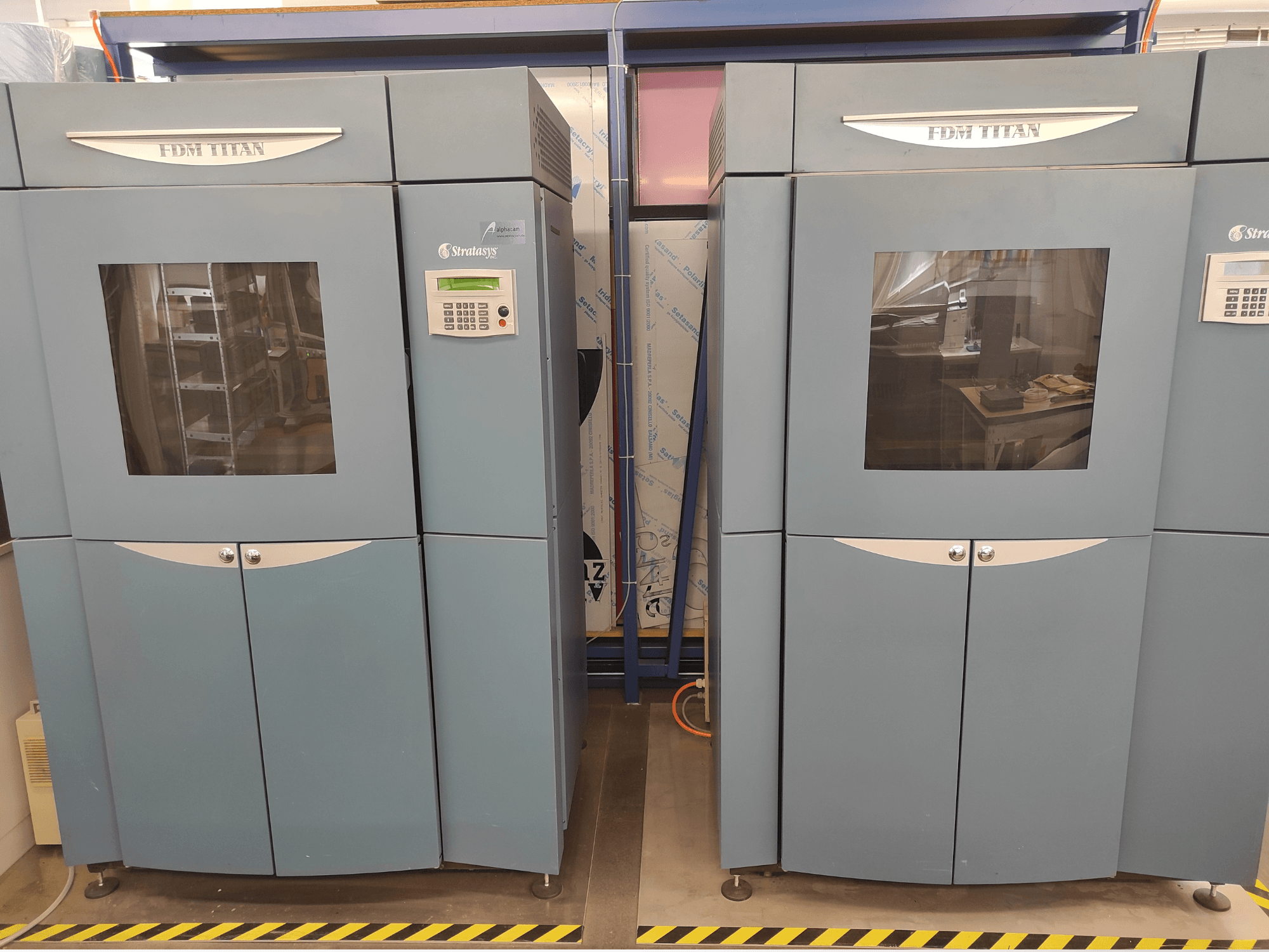 Vista frontale della stampante 3D per plastica Stratasys FDM TitanTI T0031; dotata di pannello di controllo e finestra trasparente.