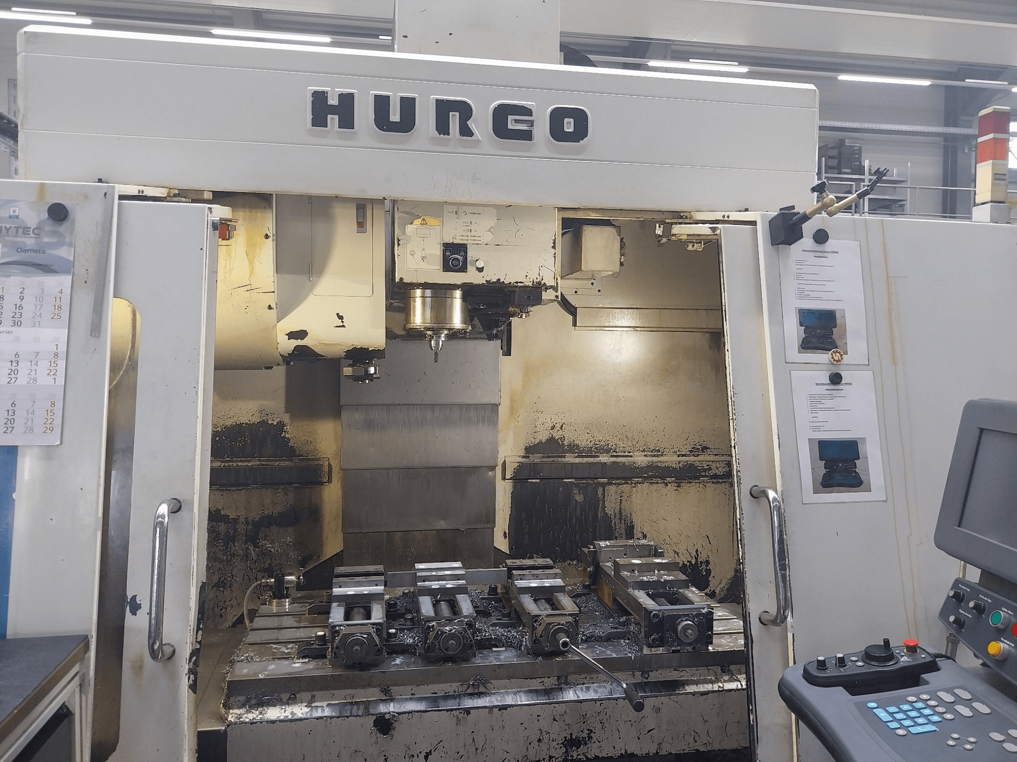 Centro di lavoro verticale Hurco VMX 42 vista frontale, mostra il piano di lavoro con le attrezzature e il pannello di controllo, condizioni leggermente usurate.