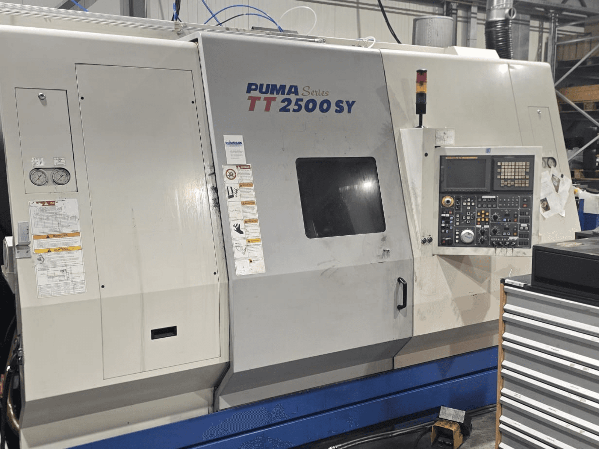Tornio CNC PUMA Serie TT 2500 SY, vista frontale; pannello di controllo con quadranti e pulsanti, indicatori ed etichette operative visibili.