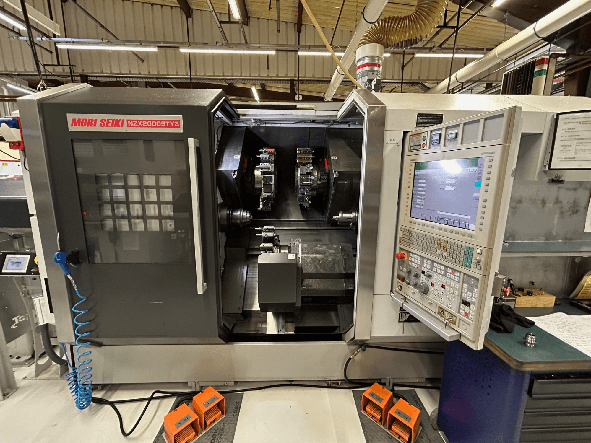 Tornio multimandrino MORI SEIKI NZ2000 ST3Y3, vista frontale che mostra il pannello di controllo e l'area di lavorazione.