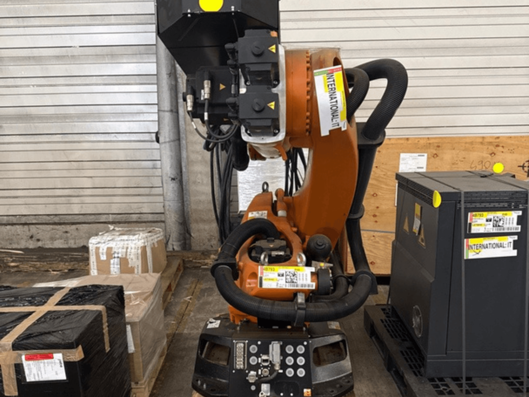 Braccio robotico aggiuntivo KUKA KR 210 R2700 in vista frontale, esposto su un pallet accanto a colli e attrezzature.