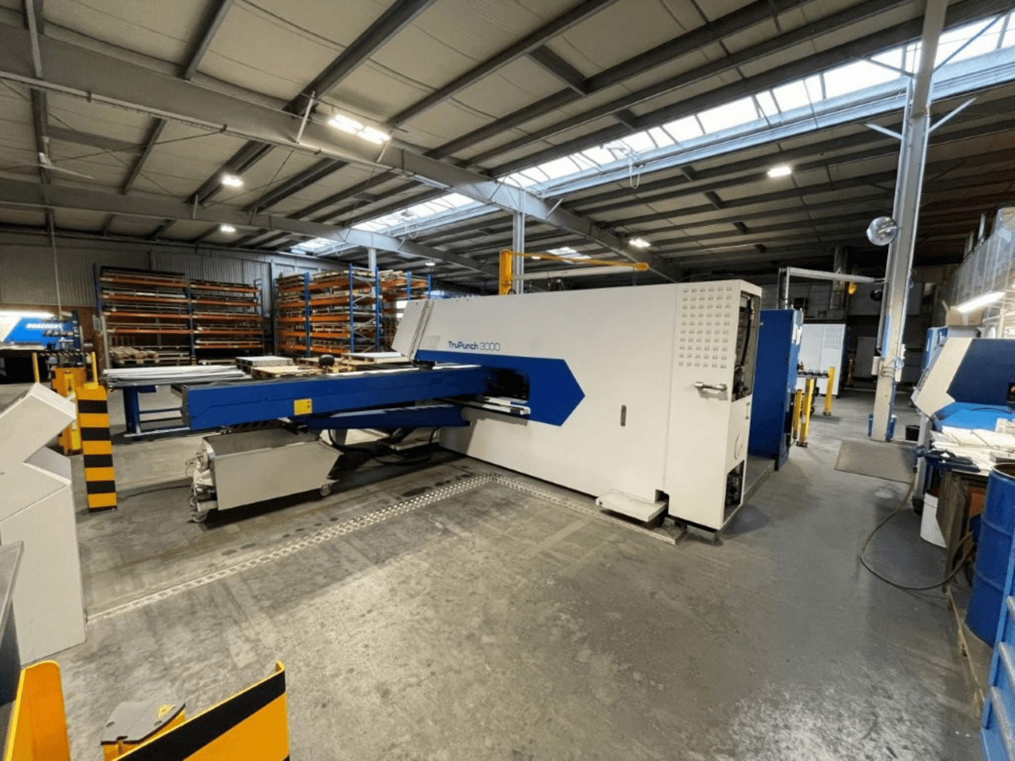 La punzonatrice CNC TRUMPF TruPunch 3000 in un ambiente industriale; la vista frontale ne mette in risalto il design blu e bianco e i componenti operativi.