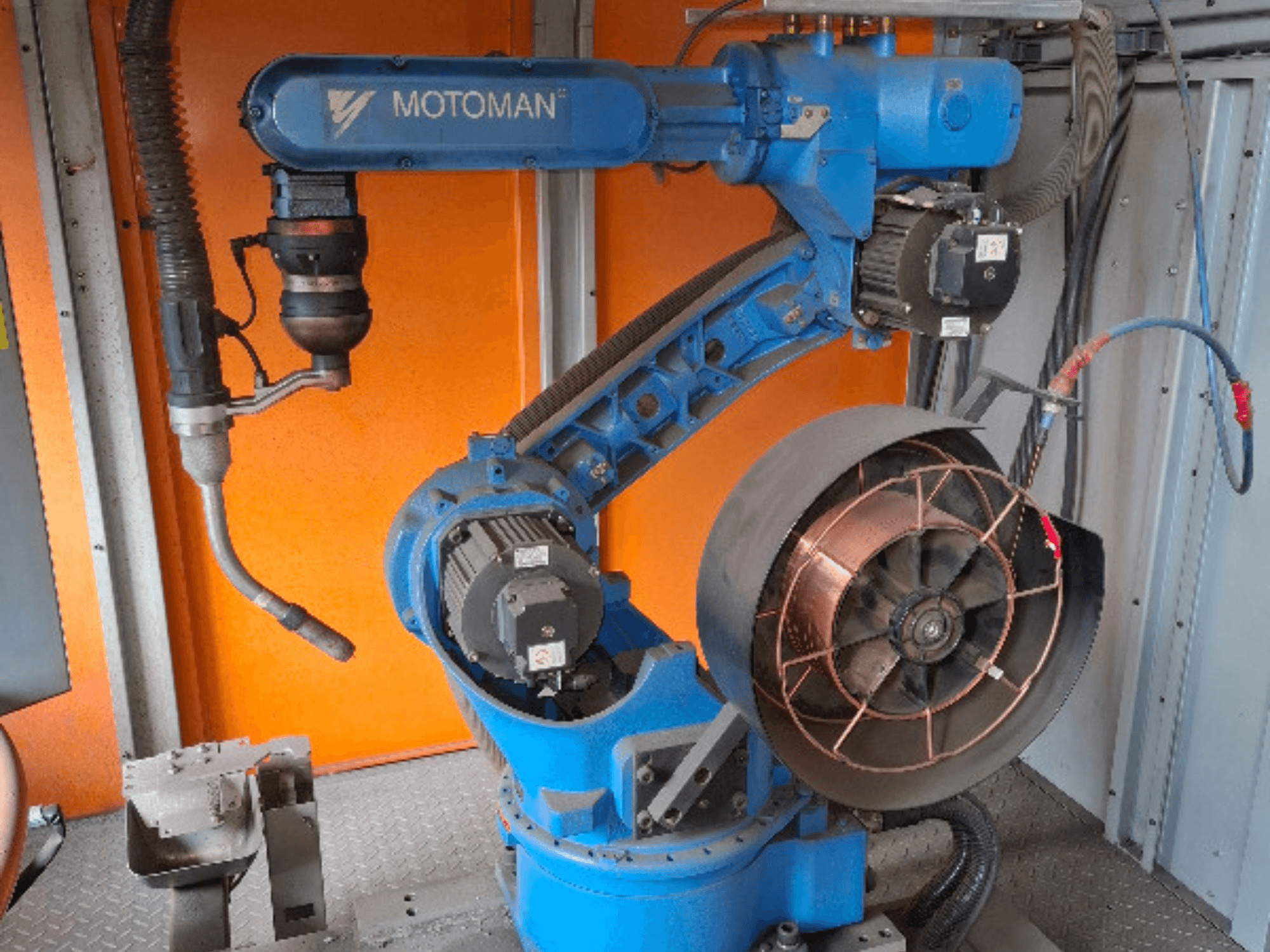 Braccio robotico MOTOMAN in blu, vista laterale, con ventola e utensili collegati, con dettagli meccanici e connessioni.