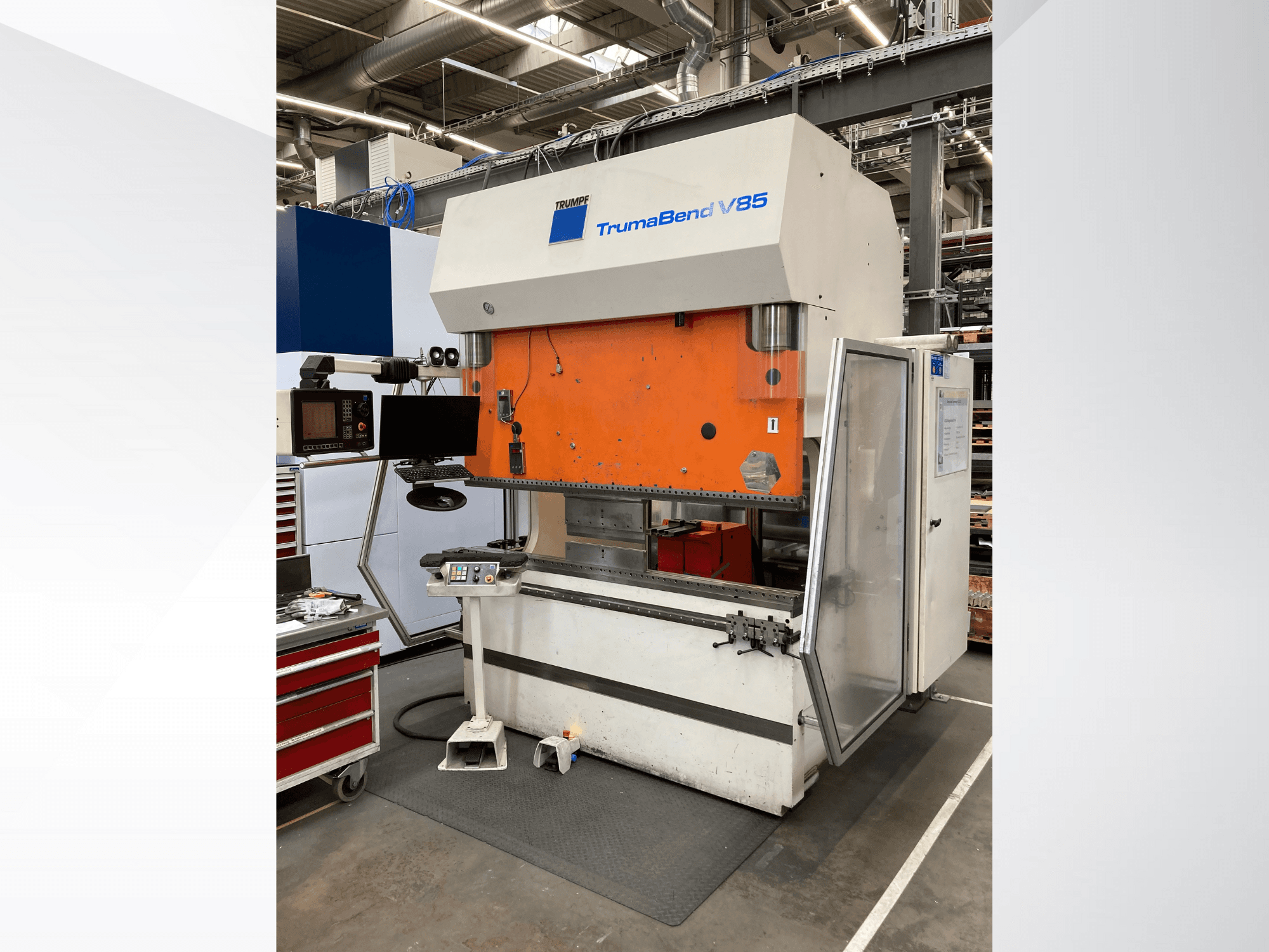 Curvatrice TruMatic V85 in uno stabilimento, con pannello frontale arancione, schermo di controllo e porta laterale aperta, vista laterale.