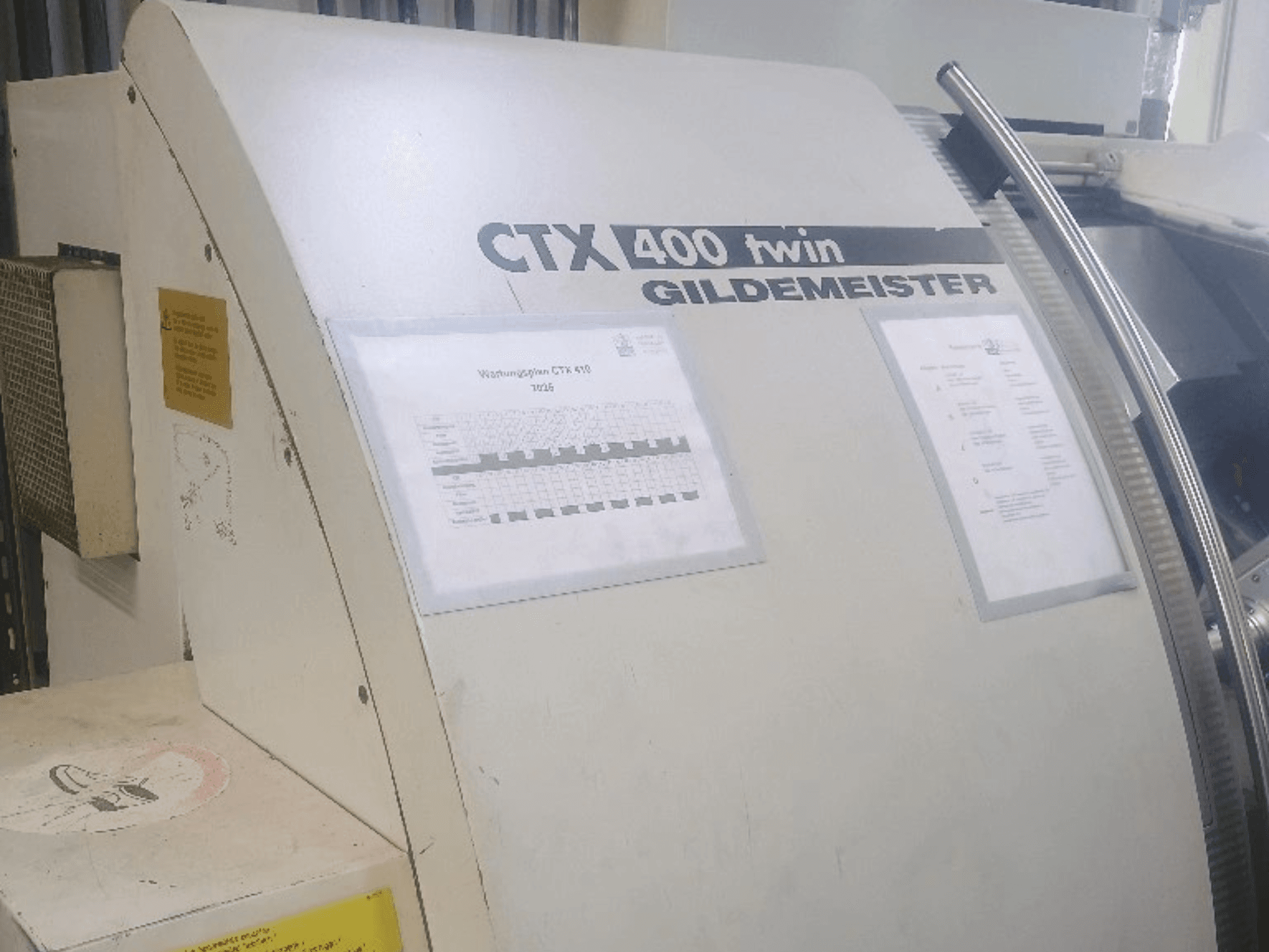 Tornio orizzontale doppio Gildemeister CTX 400, vista frontale, con i pannelli di comando e la documentazione tecnica.