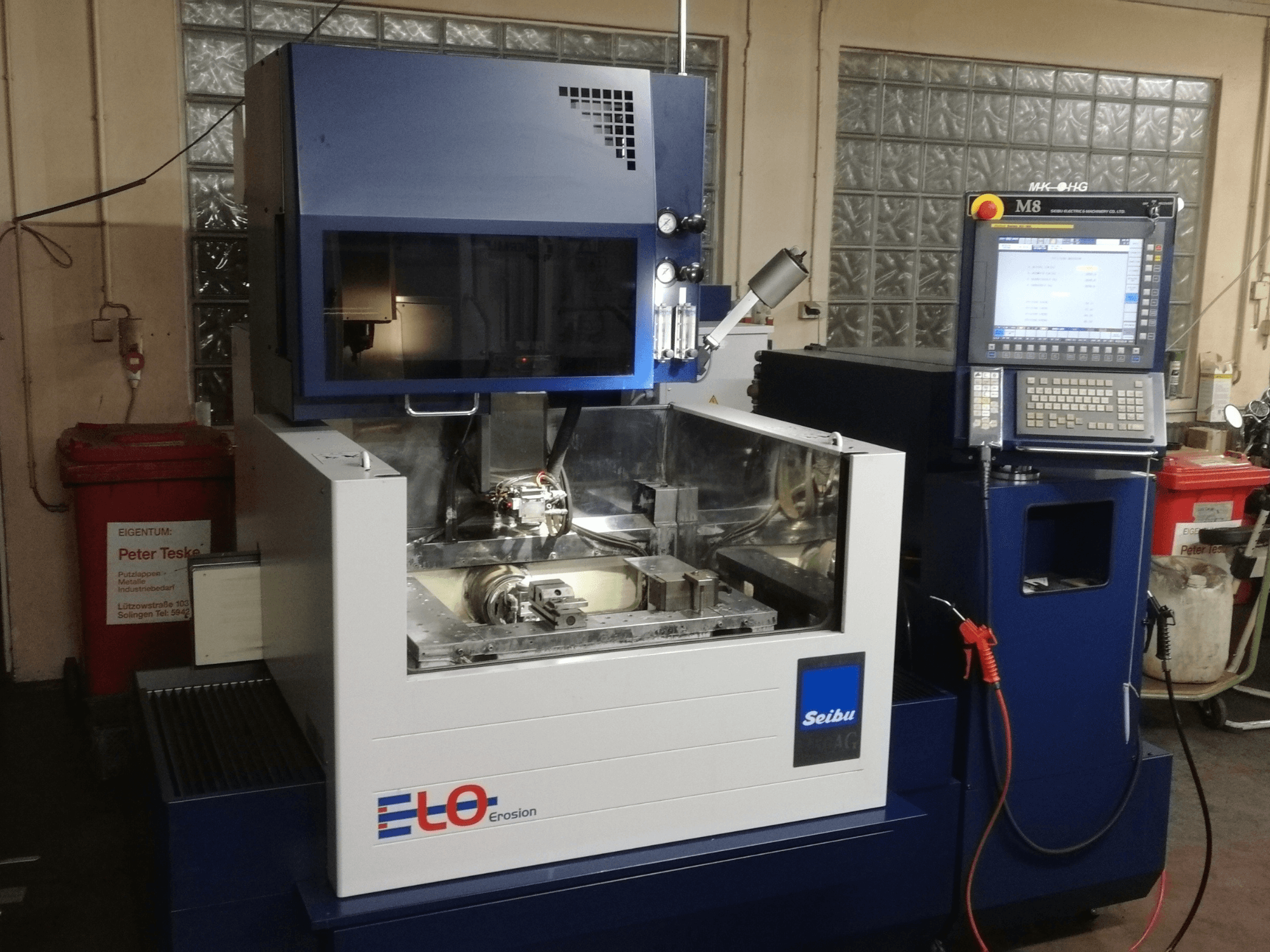 Macchina per erosione ELO Seibu vista frontalmente, con pannello di controllo e area di lavoro visibile con componenti metallici.