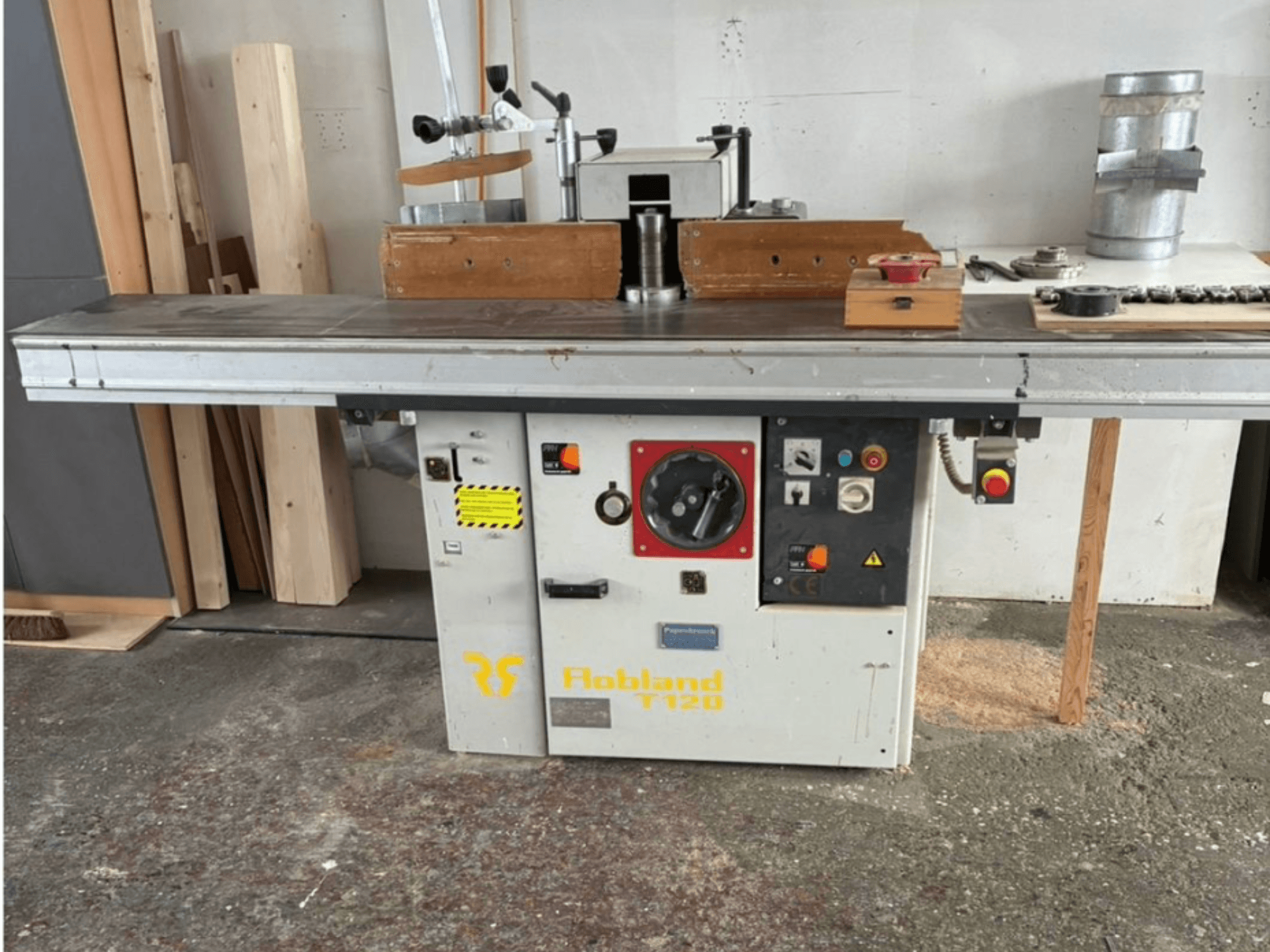 La pialla da tavolo Hobbland T120, vista frontale, presenta una superficie argentata, un pannello di controllo con pulsanti ed etichette di sicurezza.